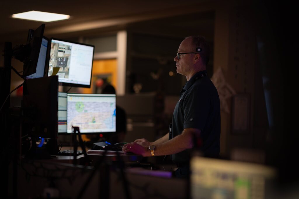 A KCCDA dispatch operator works in a darkened office.