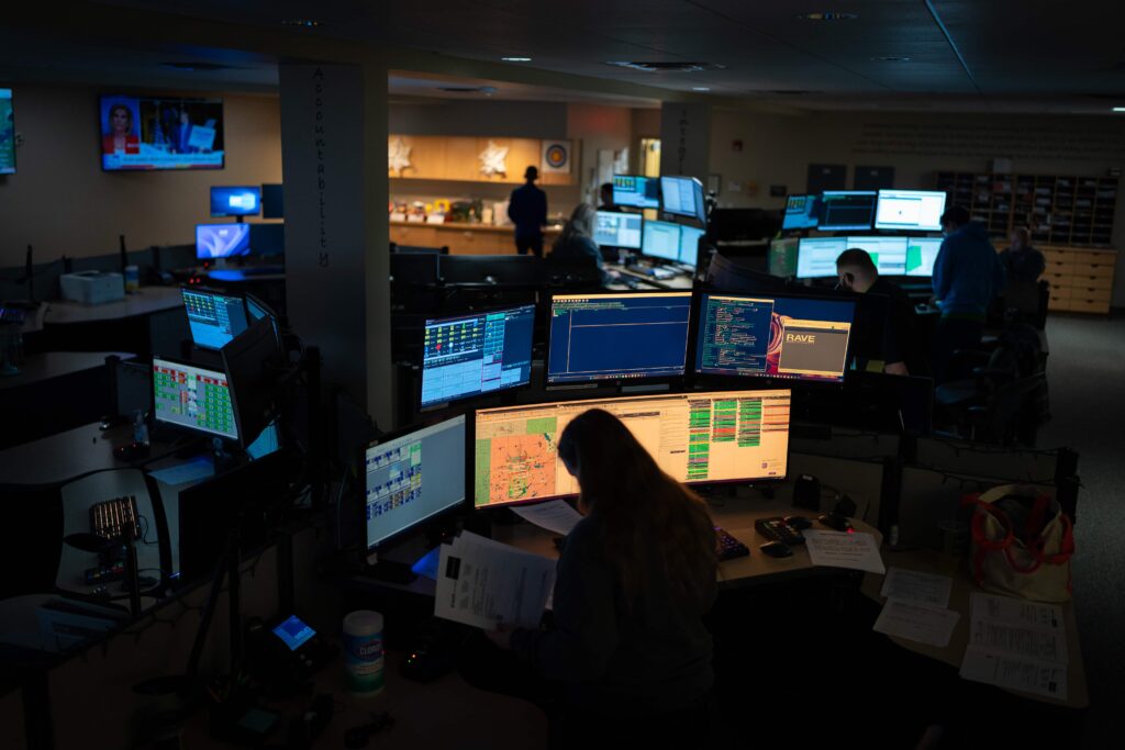 A wide shot of the entire KCCDA dispatch room, with a number of computers and workers.