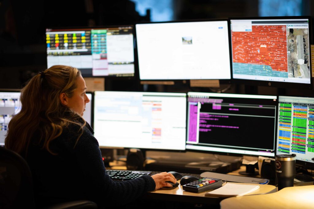A police dispatcher in Kalamazoo monitors a bank of screens.